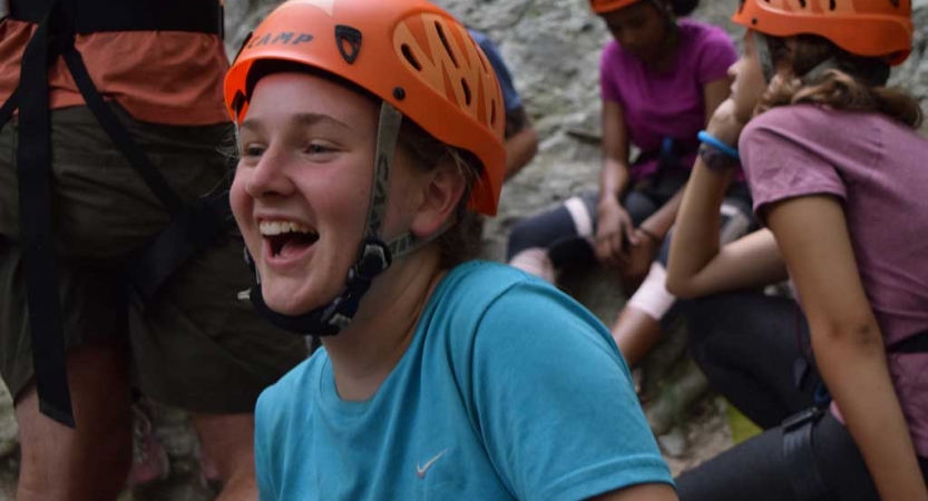 A person wearing an orange helmet laughs